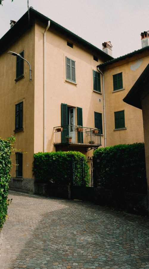 Scenic view of a classic European townhouse with a charming balcony and paved alley